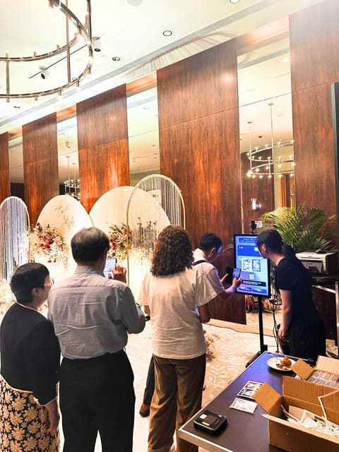 Guests gathered around the photo booth at an indoor event.