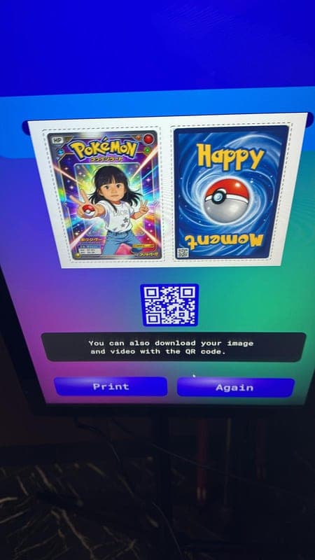 The booth screen showing two finished cards and a QR code to download them.