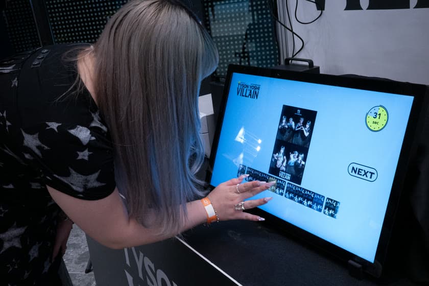 A fan choosing a frame on the concert photo booth touchscreen.