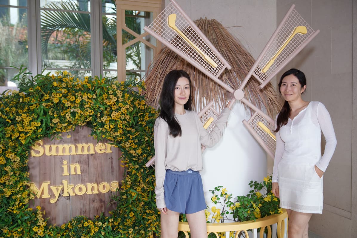 Two guests photographed in a Mediterranean-themed event set.
