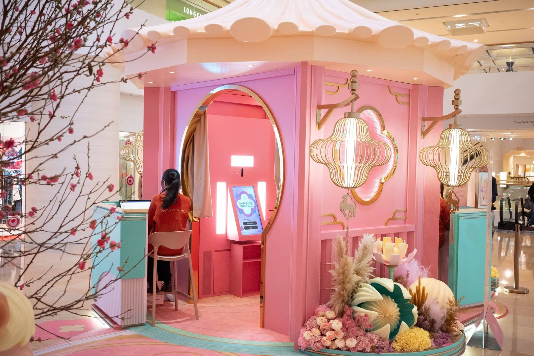 The pink Pacific Place Lunar New Year photo booth pavilion among plum blossoms in the mall.