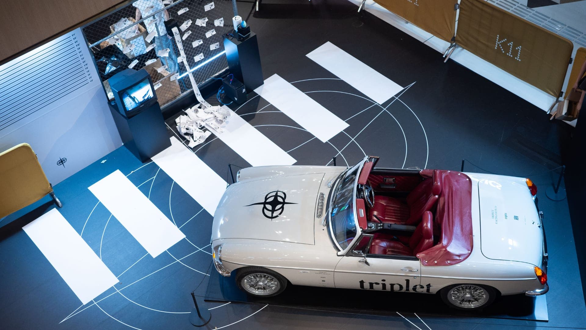 A white convertible on a zebra-crossing set at the Triplet installation in K11 Art Mall.