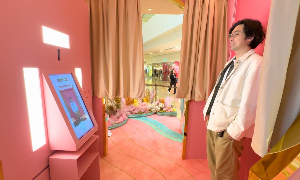 A guest posing inside a pink Lunar New Year photo booth.